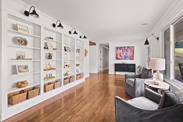 living area with visible vents and wood finished floors