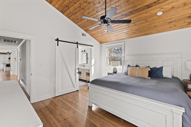 bedroom featuring wood ceiling, a barn door, visible vents, and wood finished floors