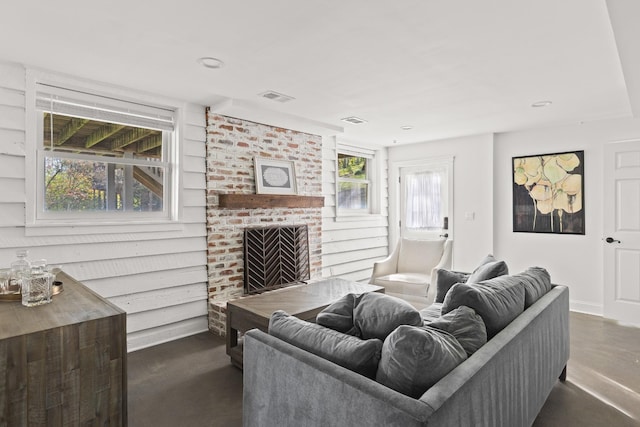 living room featuring baseboards, a fireplace, and visible vents