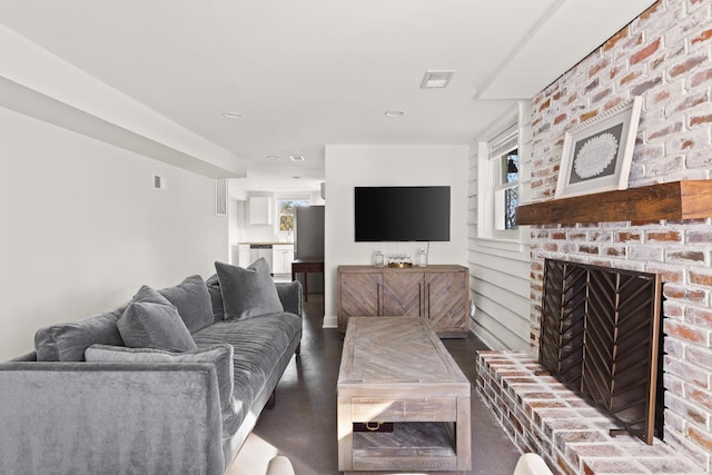 living area with a fireplace, wood finished floors, and visible vents