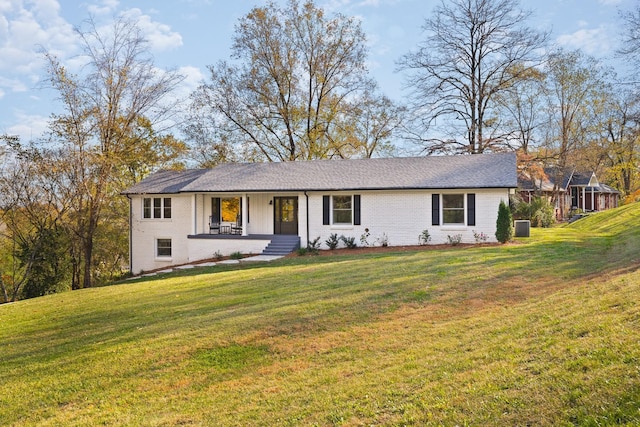 ranch-style home featuring covered porch, a front lawn, and brick siding