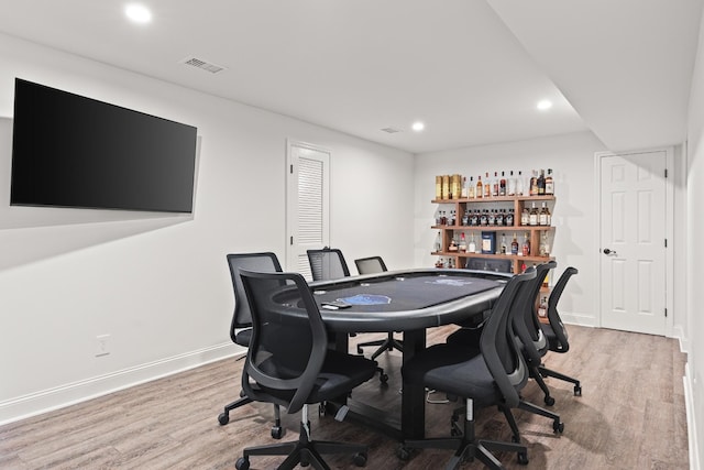 office area featuring light wood-style flooring, recessed lighting, visible vents, baseboards, and a dry bar