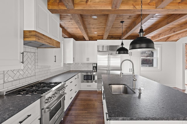 kitchen featuring a kitchen island with sink, stainless steel appliances, a sink, white cabinets, and decorative light fixtures