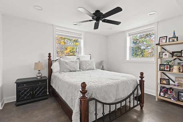 bedroom with multiple windows, baseboards, and concrete flooring