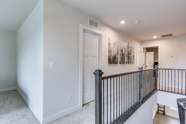 hallway with light carpet, baseboards, visible vents, and recessed lighting