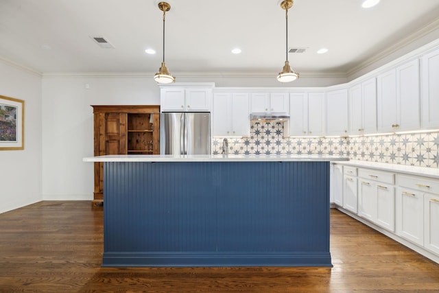 kitchen with decorative backsplash, visible vents, stainless steel refrigerator, and dark wood-type flooring