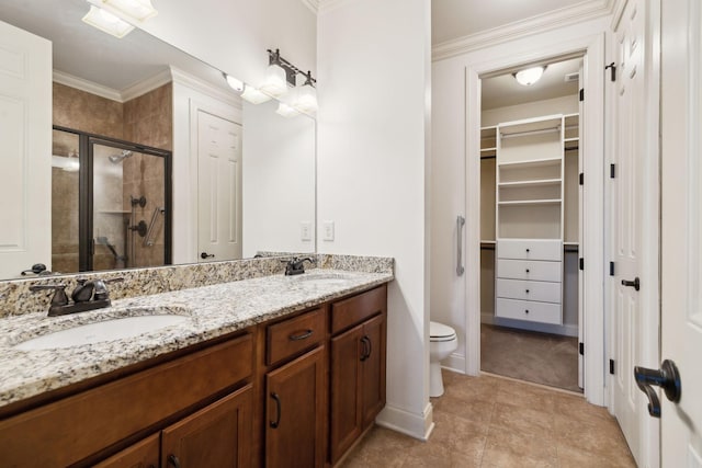 full bathroom with a sink, ornamental molding, double vanity, a stall shower, and a walk in closet