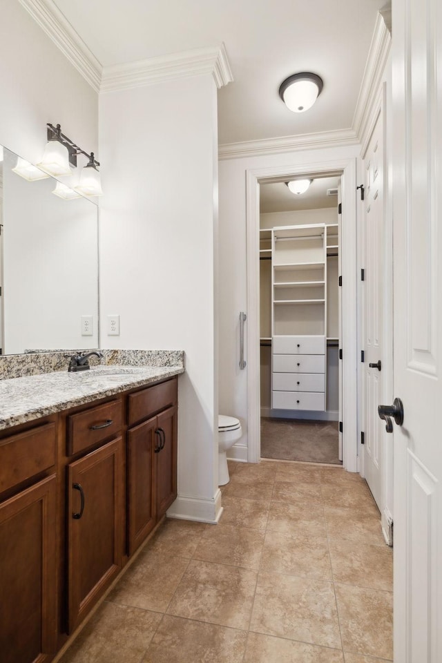 full bathroom with toilet, vanity, baseboards, a spacious closet, and ornamental molding