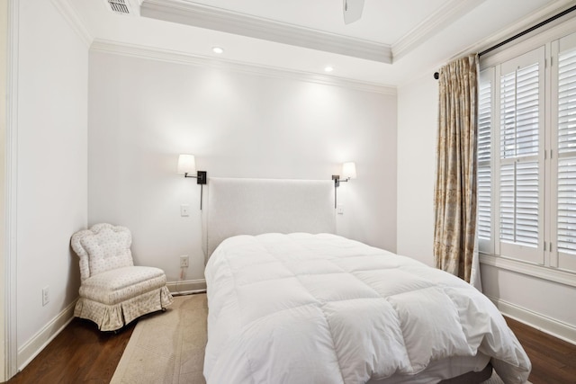 bedroom featuring multiple windows, baseboards, a raised ceiling, and wood finished floors