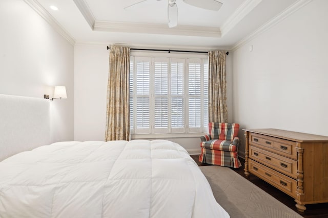 bedroom with ornamental molding, a tray ceiling, and multiple windows