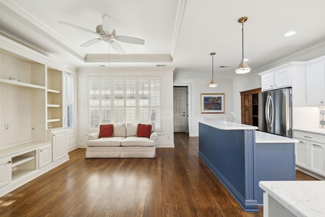 kitchen featuring white cabinets, dark wood-style flooring, freestanding refrigerator, and crown molding