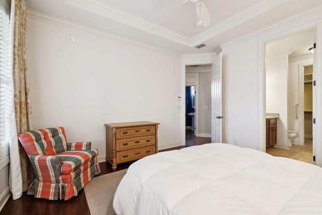 bedroom with ornamental molding, wood finished floors, visible vents, and baseboards