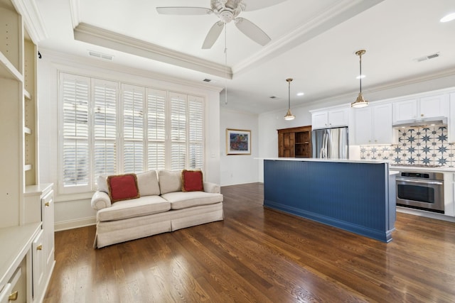 unfurnished living room with dark wood-style flooring, visible vents, a raised ceiling, and crown molding