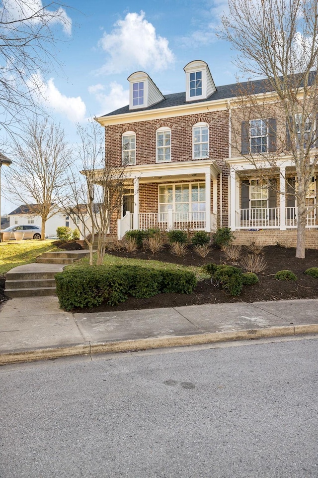 view of front of house with covered porch and brick siding