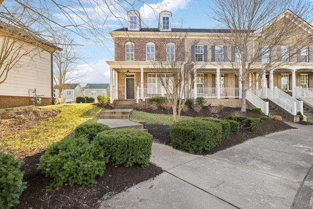 view of front facade with covered porch and brick siding