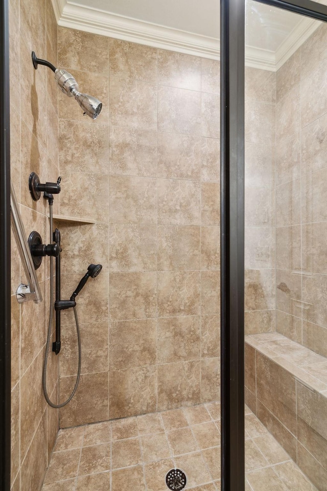 bathroom featuring crown molding and a tile shower