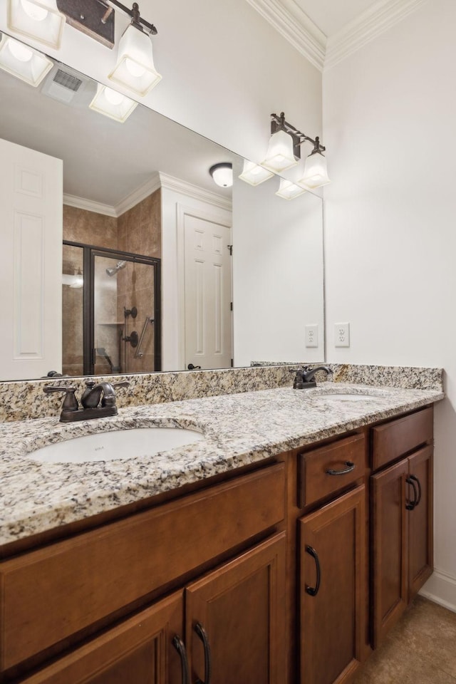 bathroom featuring double vanity, ornamental molding, a stall shower, and a sink