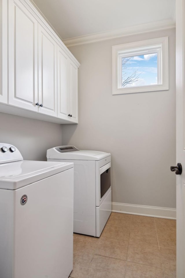 laundry area featuring crown molding, washer and clothes dryer, light tile patterned floors, cabinet space, and baseboards