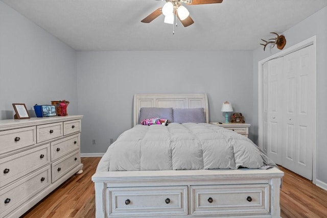 bedroom featuring a closet, ceiling fan, light wood-style flooring, and baseboards