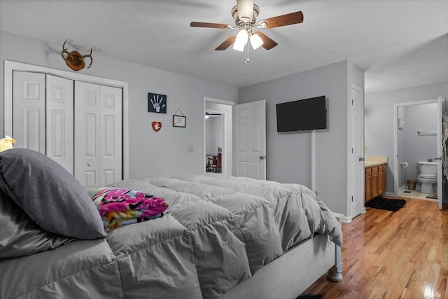 bedroom featuring light wood finished floors, baseboards, connected bathroom, ceiling fan, and a closet