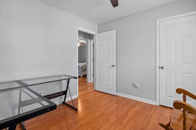 bedroom with light wood-style floors, baseboards, and a ceiling fan