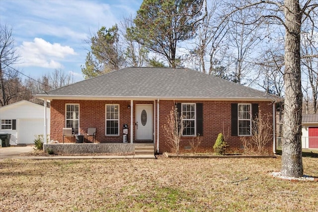 single story home featuring brick siding, roof with shingles, covered porch, a front yard, and an outdoor structure