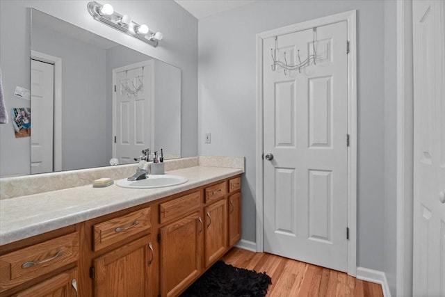 bathroom featuring baseboards, wood finished floors, and vanity