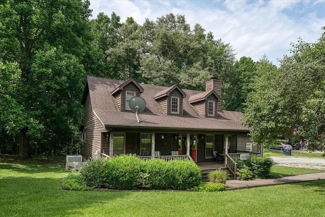 cape cod-style house with a chimney, a porch, a shingled roof, a front yard, and central AC