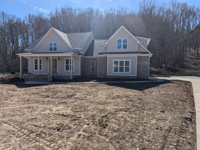 craftsman-style home with covered porch, brick siding, and board and batten siding