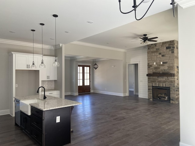 kitchen with a large fireplace, a ceiling fan, dishwasher, open floor plan, and a sink