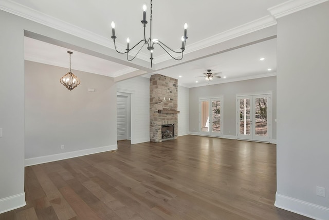 unfurnished living room with crown molding, baseboards, dark wood-type flooring, and a stone fireplace