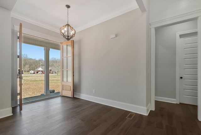 unfurnished dining area featuring baseboards, ornamental molding, dark wood finished floors, and a notable chandelier