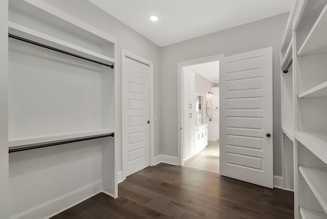 walk in closet with dark wood-style flooring