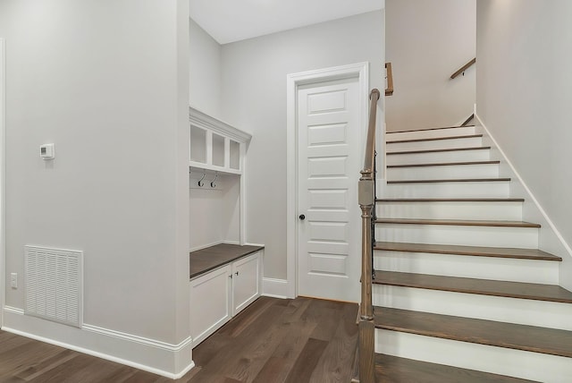 mudroom featuring dark wood-type flooring, visible vents, and baseboards