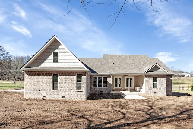 rear view of property with roof with shingles, crawl space, french doors, a patio area, and brick siding