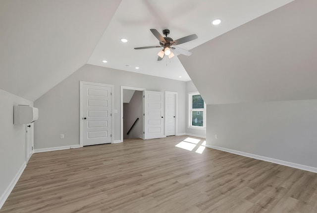 additional living space featuring light wood-type flooring, baseboards, vaulted ceiling, and recessed lighting