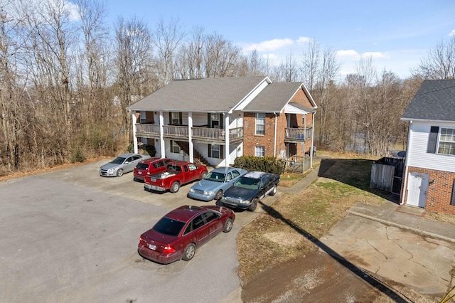 view of front facade featuring brick siding and a balcony