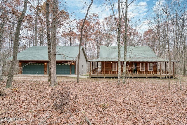 view of front of home featuring covered porch, metal roof, and a garage