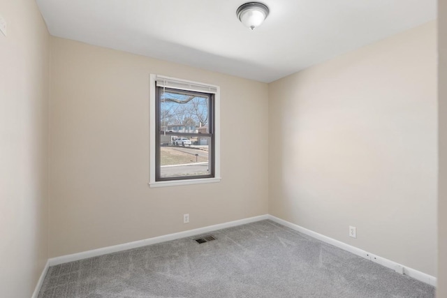 spare room featuring baseboards, visible vents, and carpet flooring