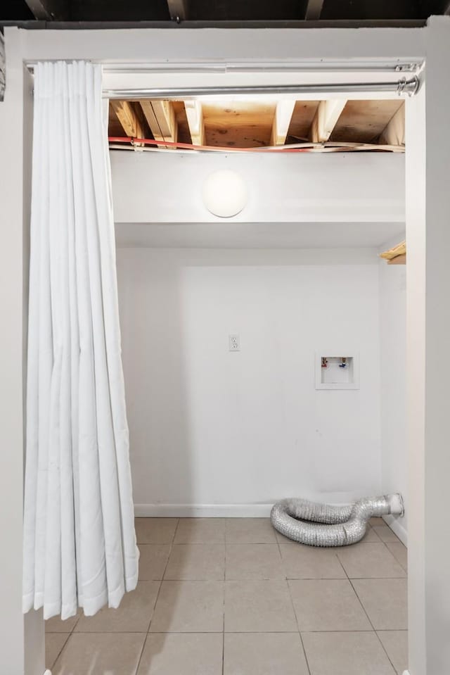 laundry area featuring hookup for a washing machine, laundry area, light tile patterned flooring, and baseboards