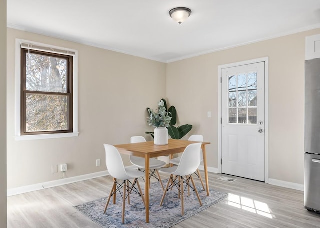 dining space featuring a wealth of natural light, baseboards, and light wood finished floors