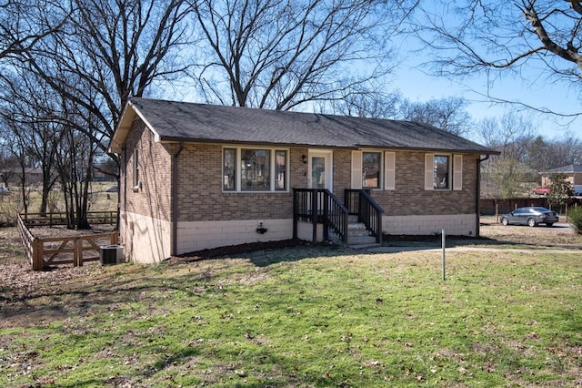 view of front facade featuring brick siding, a front lawn, and central air condition unit