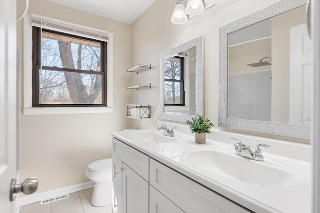 full bath with a wealth of natural light, visible vents, a sink, and toilet