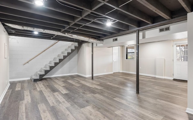 below grade area featuring stairway, visible vents, and wood finished floors