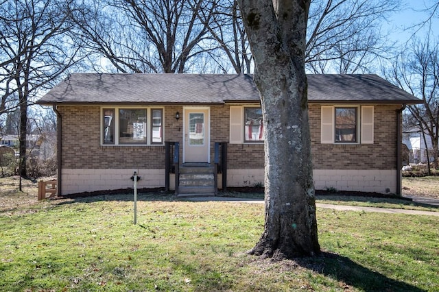 single story home featuring a front yard, brick siding, and roof with shingles