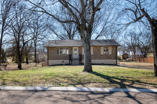 single story home featuring a front yard, fence, and brick siding