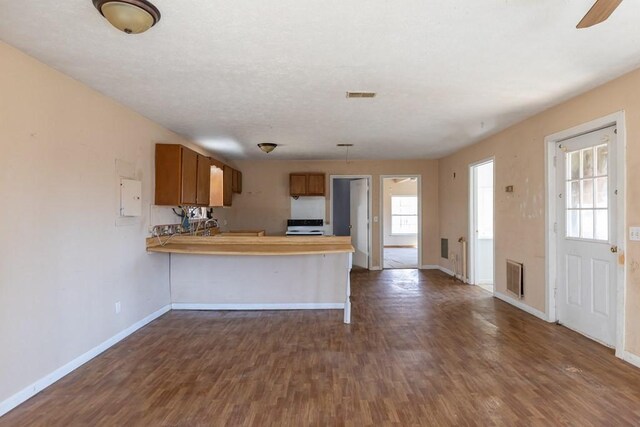 224 Golden Ln, Celina, TN 38551 - kitchen featuring a peninsula, dark wood-type flooring, light countertops, electric range oven, and brown cabinetry