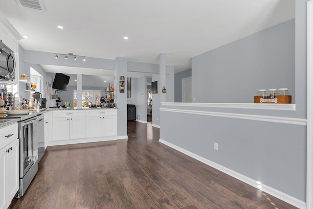 kitchen featuring visible vents, light stone counters, white cabinets, and electric stove