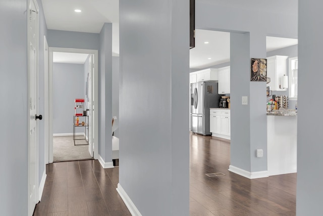 hall with dark wood-style floors, recessed lighting, visible vents, and baseboards