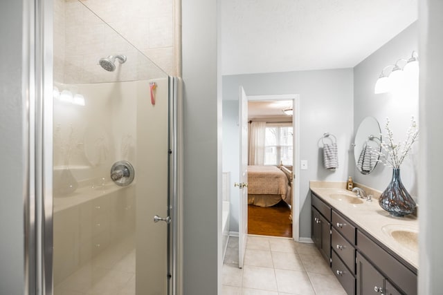 ensuite bathroom with double vanity, a stall shower, ensuite bath, and tile patterned flooring